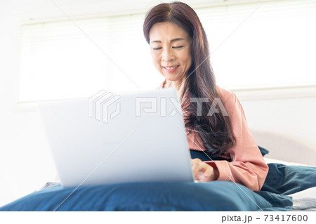 ベッドでパソコンをする女性 73417600