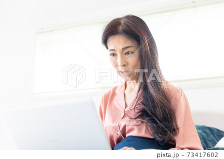 ベッドでパソコンをする女性 73417602