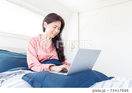 ベッドでパソコンをする女性 ベッドでパソコンをする女性 73417606