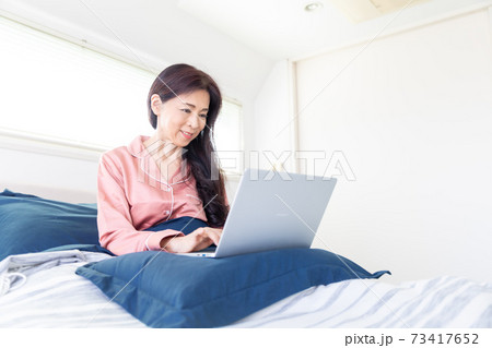 ベッドでパソコンをする女性 ベッドでパソコンをする女性 73417652