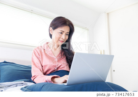 ベッドでパソコンをする女性 ベッドでパソコンをする女性 73417653
