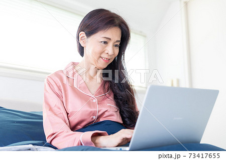 ベッドでパソコンをする女性 73417655