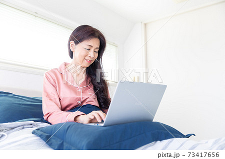 ベッドでパソコンをする女性 ベッドでパソコンをする女性 73417656