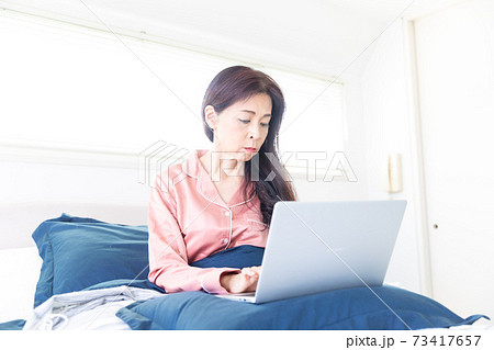 ベッドでパソコンをする女性 73417657