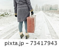 Woman with vintage suitcase in winter 73417943