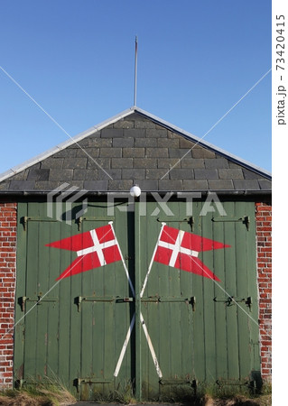 Danish flag on a green door in Denmark 73420415