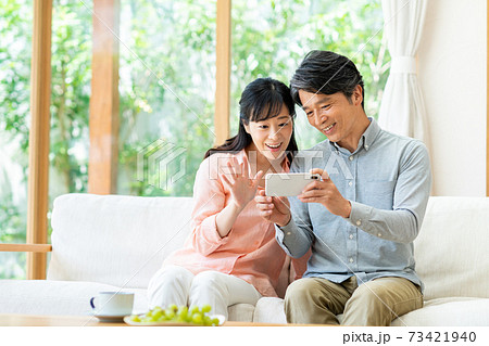 スマホでビデオ通話するミドルの夫婦 73421940