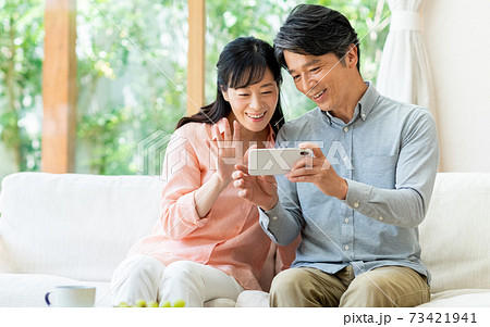 スマホでビデオ通話するミドルの夫婦 73421941