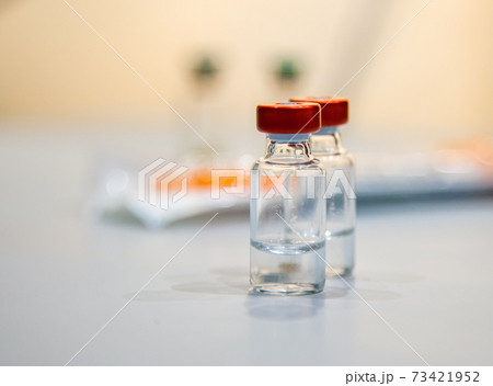 closeup of two vaccine bottles, selective focus closeup of two vaccine bottles, selective focus 73421952