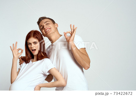 a pregnant woman and a young man are waiting for a baby on a light background emotions family love a pregnant woman and a young man are waiting for a baby on a light background emotions family love 73422672