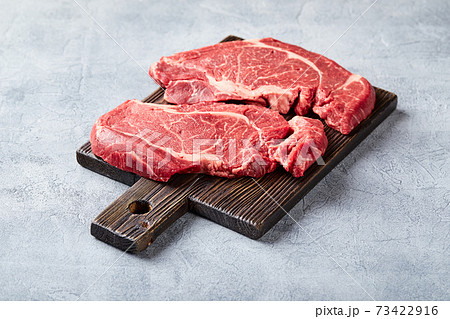 Two Fresh Raw meat Prime Black Angus Beef Steaks, Rib Eye, Denver, on wooden cutting board 73422916