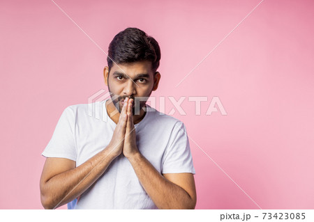 Portrait of handsome Indian guy standing on pink background 73423085