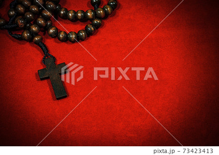 Old Wooden Crucifix with Rosary Beads on Red Velvet Background Old Wooden Crucifix with Rosary Beads on Red Velvet Background 73423413