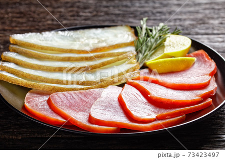 Smoked halibut and tuna slices, top view, close-up 73423497