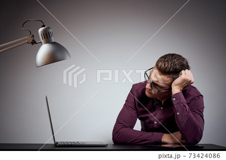 businessman in glasses and a shirt sits at a table with open laptops Coffee Space mobile phone businessman in glasses and a shirt sits at a table with open laptops Coffee Space mobile phone 73424086
