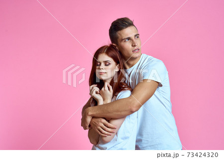 lovers man and woman in jeans and t-shirt on pink background cropped view family romance teenagers lovers man and woman in jeans and t-shirt on pink background cropped view family romance teenagers 73424320