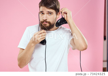 Man with two joysticks in hands fun game technology lifestyle pink background 73424325