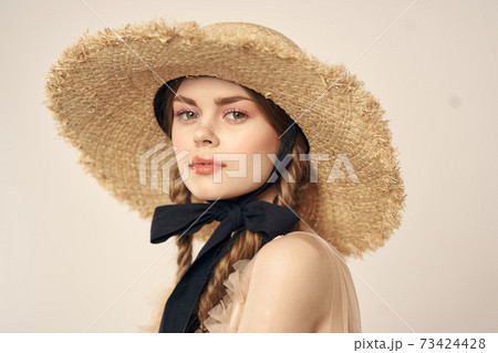 portrait of a romantic girl in a dress and a straw hat with a black ribbon emotions cropped view 73424428