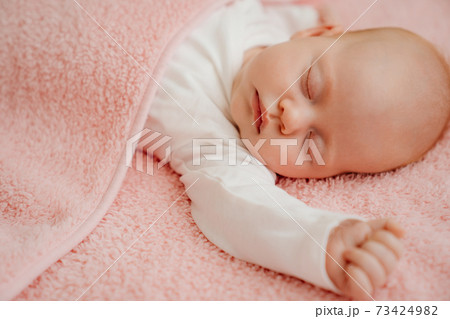sleeping baby under the pink blanket. healthy sleep in newborns. sleeping baby under the pink blanket. healthy sleep in newborns. 73424982