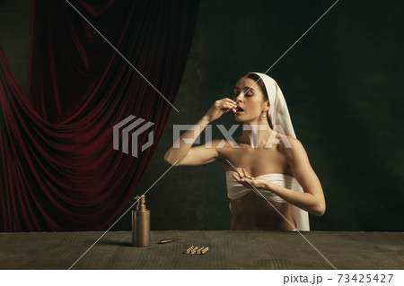 Modern remake of classical artwork with coronavirus theme - young medieval woman on dark background 73425427