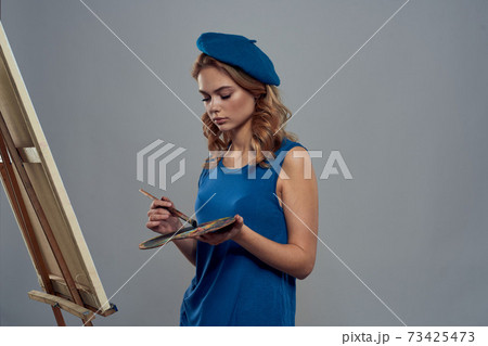 woman artist blue beret palette drawing on easel art creativity light background 73425473