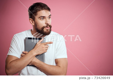 Man advertises a tablet on a pink background codes Space cropped view of emotions white t-shirt model new technologies 73426649
