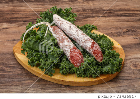 Spanish Fuet sausage with salad leaves 73426917