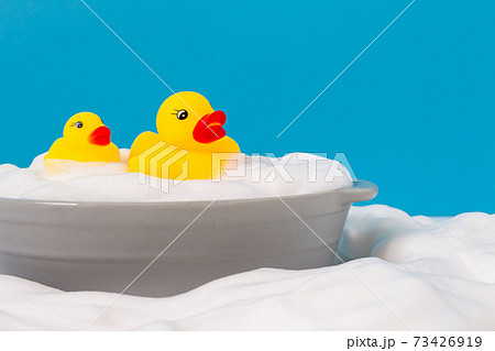 おもちゃのアヒルとせっけんの泡 入浴イメージ素材の写真素材