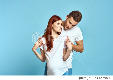 Pregnant woman in white t-shirt and man married couple waiting for baby blue background cropped view of emotions Pregnant woman in white t-shirt and man married couple waiting for baby blue background cropped view of emotions 73427901