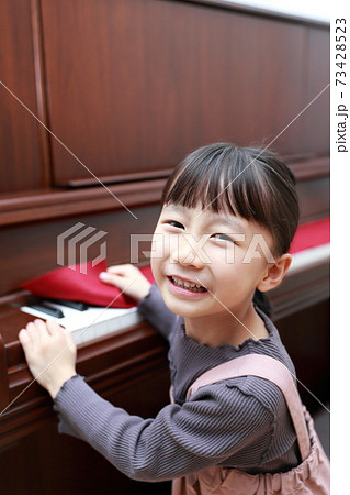アップライトピアノを弾こうとする5歳の女の子 73428523