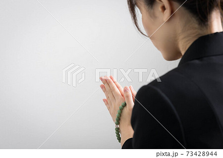 葬儀で手を合わせてお参りする若い女性 葬儀で手を合わせてお参りする若い女性 73428944