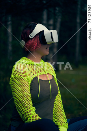 Woman goes into virtual reality using virtual reality headset. 73428986