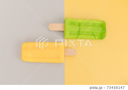 Ice cream stick on gray and yellow background. 73430147