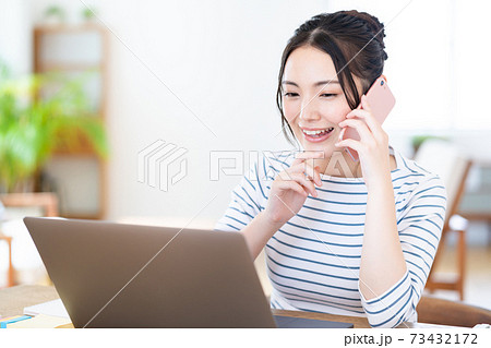 リビングでテレワーク中の若い女性 73432172