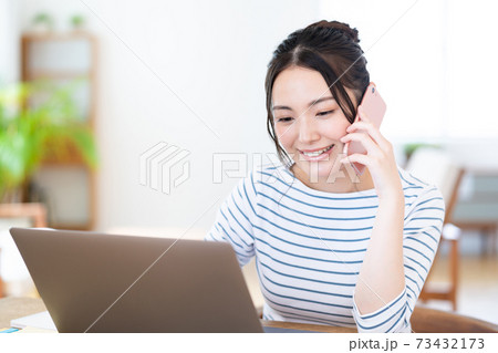 リビングでテレワーク中の若い女性 73432173