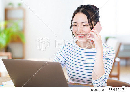 リビングでテレワーク中の若い女性 リビングでテレワーク中の若い女性 73432174