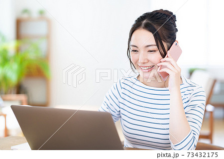 リビングでテレワーク中の若い女性 リビングでテレワーク中の若い女性 73432175