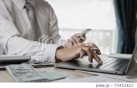 Financial businessmen use laptop and smart phone to analyze marketing strategies and real estate data to reduce company taxes for their customers, Accounting and Tax concept. 73432822