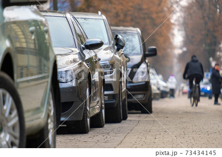 Cars parked in a row on a city street side. Cars parked in a row on a city street side. 73434145