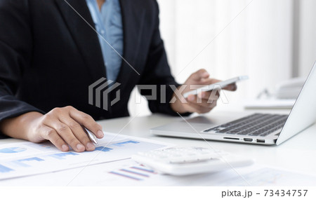 Financial businesswomen use laptop and smart phone to analyze marketing strategies and real estate data to reduce company taxes for their customers, Accounting and Tax concept. 73434757
