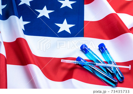 Virus cell usa. Medical syringe with needle for protection flu virus and coronavirus. Covid vaccine on american flag background. Health care in hospital. 73435733