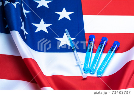 Virus cell usa. Medical syringe with needle for protection flu virus and coronavirus. Covid vaccine on american flag background. Health care in hospital. Virus cell usa. Medical syringe with needle for protection flu virus and coronavirus. Covid vaccine on american flag background. Health care in hospital. 73435737