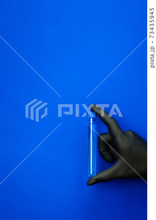 Syringe isolated. Doctor hand in medical glove hold test tube or bottle for protection flu virus and coronavirus. Covid vaccine isolated on blue. Concept fight against virus covid-19. 73435945