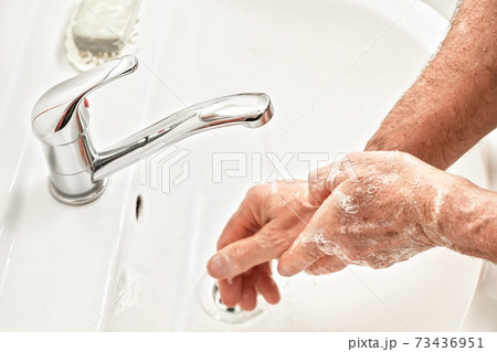Senior elderly man his hands under tap water faucet, detail photo. Can be used as hygiene illustration concept during coronavirus / covid-19 outbreak prevention 73436951