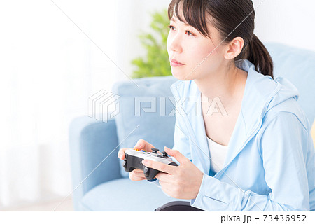 ソファに座ってネットゲームをプレイする女性 73436952