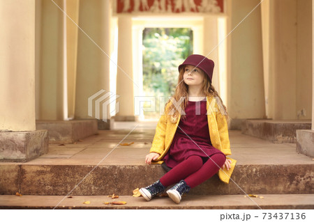 Irish little red haired girl outdoor photo on park architecture background Irish little red haired girl outdoor photo on park architecture background 73437136