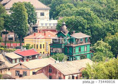 Urban landscape with aged houses and green trees in summer Kaunas 73440016