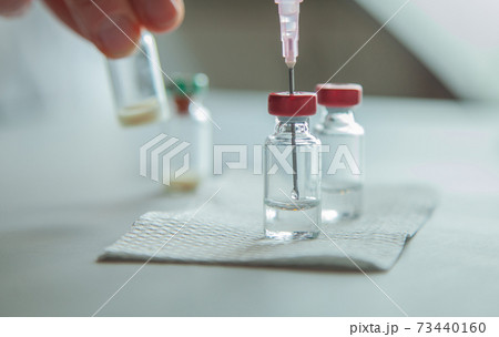 vaccine bottles and syringe for injection 73440160