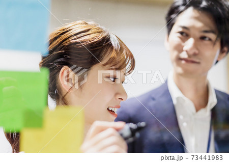 会議室で透明ボードを使って打合せするビジネスマン 会議室で透明ボードを使って打合せするビジネスマン 73441983