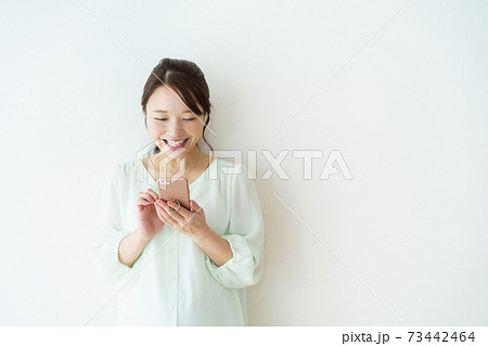スマートフォンを見る女性　白背景 73442464
